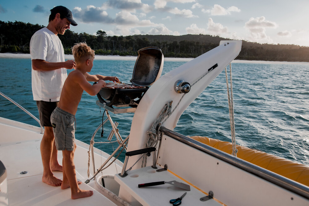 Vater und Sohn beim grillen auf einem Boot